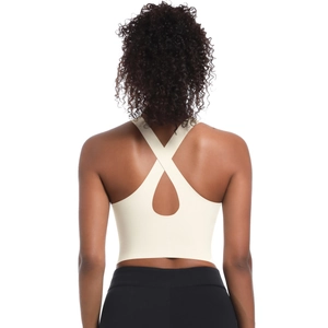 Détail du dos d'une brassière de sport crème avec design de bretelles croisées