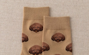 Close-up of khaki knitted socks with cute brown teddy dog embroidery and ribbed cuffs