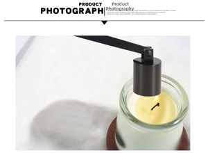 Close-up of matte black stainless steel candle snuffer extinguishing a candle flame