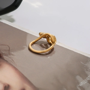 Detailed view of gold twisted snake ring with zircon inlay on wellness magazine