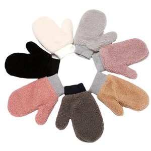 Detailed overhead view showing seven colors of plush lamb wool mittens for children
