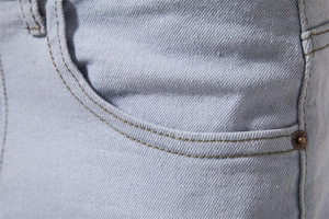 Close-up of light blue denim jeans showing pocket stitching and metal rivet detail