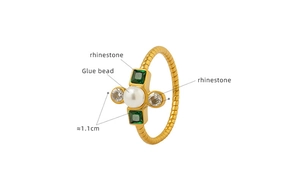 Detail view of gold-plated twisted ring band with faux pearl and green rhinestones