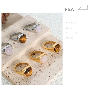 Detail shot of vintage titanium steel rings featuring natural rose quartz and tiger eye stones