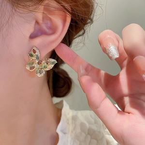 Macro view of butterfly earrings with colorful zircon stones and golden alloy setting