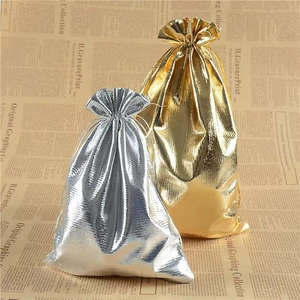 Metallic gold and silver jewelry pouches with drawstring on vintage newspaper background