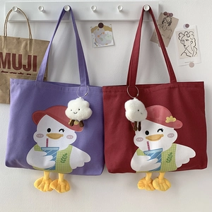 Detail of cute canvas tote bag with plush duck feet and cloud charm in purple and red