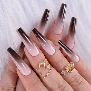 Close-up of long almond black and pink gradient press-on nails with a glossy finish