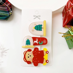 Détail de trois barrettes de Noël festives en acrylique avec Père Noël et rennes mignons