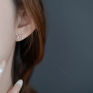 Elegant silver bow stud earrings shown on model for a minimalist daily aesthetic