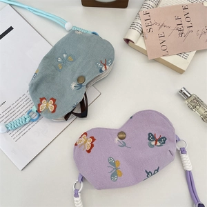 Détail de pochettes à lunettes brodées papillon en bleu et violet avec cordon tressé chic
