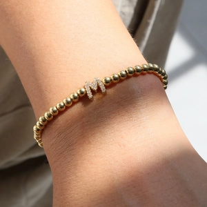 18k gold plated beaded elastic bracelet featuring a sparkling micro-paved letter M charm