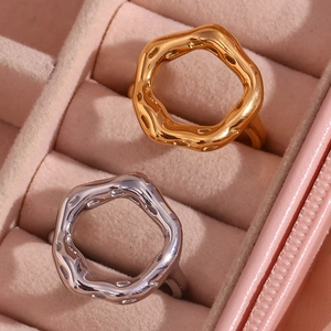 Close-up of irregular textured lava rings in gold and silver on pink velvet