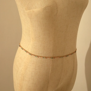 Detail of bohemian gold waist chain featuring colorful teardrop charms on a mannequin