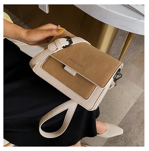 Close-up of retro crossbody bag with off-white leather and brown suede textures