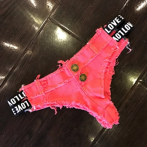 Dettaglio di hot pants in denim rosa con elastico LOVE in vita e bottoni metallici