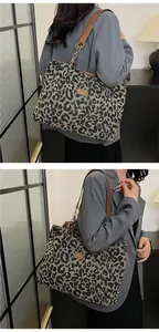 Detail view of large leopard print tote bag with leather strap and fashion label detail