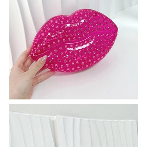 Detailed close-up of a hand holding the rose red lip-shaped evening bag with pink rhinestones