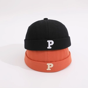 Close-up of black and orange cotton pumpkin hats with white P letter embroidery detail