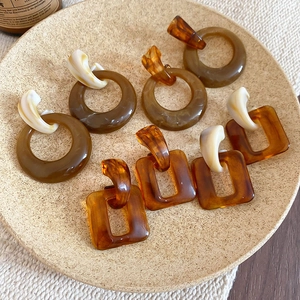 Detailed view of amber resin hoop earrings with tortoiseshell texture and ivory accents