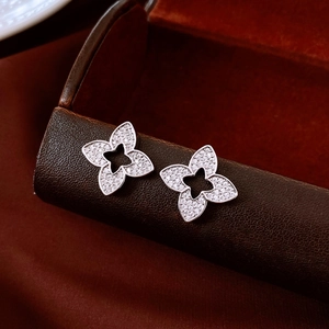 Macro shot of silver flower earrings with pave zircon stones on a leather display box