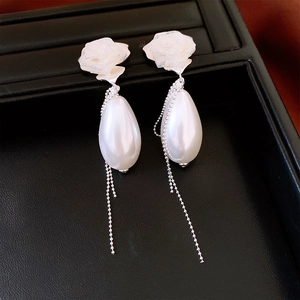Detail of elegant French style mesh rose earrings with pearl drop and silver tassel chain