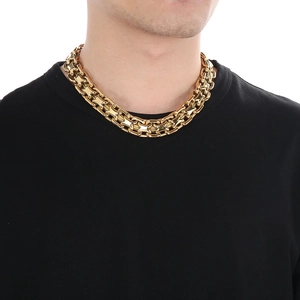 Close-up of thick gold-tone chunky curb chain necklace worn on neck by a male model