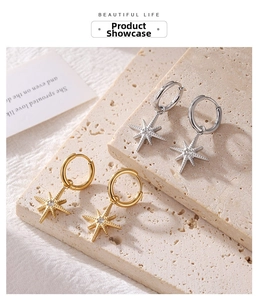 Detailed macro view of gold and silver starburst hoop earrings with zircon stones