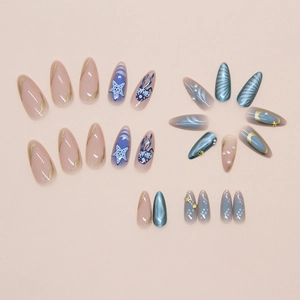 Detailed close-up of blue ocean-themed press-on nails with pearl shell and starfish accents
