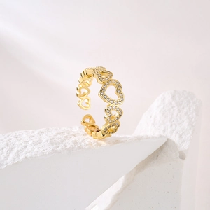 Detail of 18K gold plated hollow heart ring with sparkling pavé zircons on stone pedestal