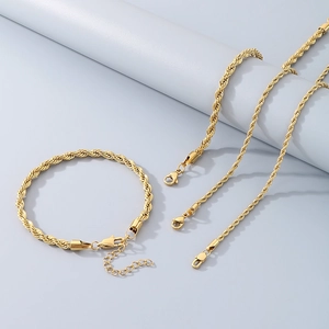 Golden minimalist twisted rope chain jewelry set with lobster clasp on grey background