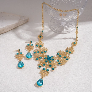 Detailed macro view of vintage gold necklace and teardrop earrings set with blue crystals