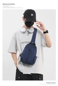 Detail of dark blue Oxford fabric chest bag with vertical zipper and top handle
