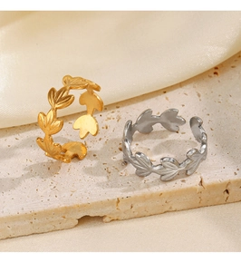 Detail showing adjustable gold and silver leaf rings on textured stone and silk