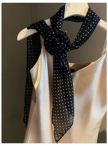 Close-up of retro black polka dot chiffon flower scarf necklace on a silk camisole