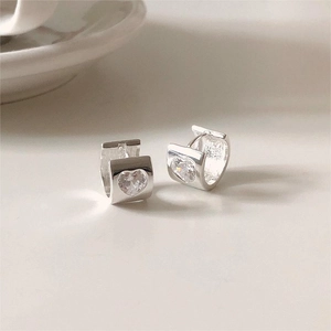 Minimalist 925 sterling silver heart zircon earrings shown on a soft aesthetic background