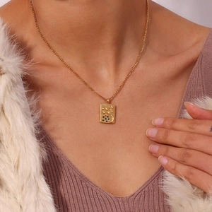 Detail of 18K gold-plated necklace featuring a rectangular celestial star and moon pendant