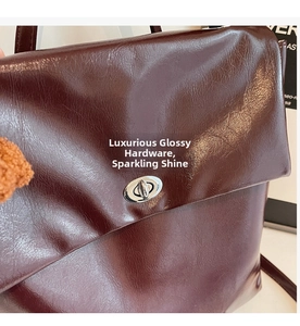 Close-up of a vintage dark burgundy backpack featuring glossy crinkled leather and a silver lock