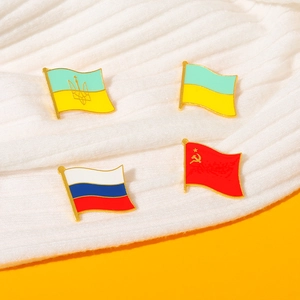 Spille in metallo con bandiere di Ucraina, Russia e URSS su un tessuto a maglia bianco