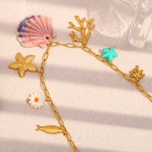 Détail de la chaîne plaquée or 18K avec coquillage rose et breloques de style marin