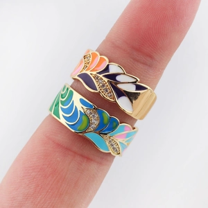 Close-up of colorful enamel wave rings with gold plating and zircon inlay on finger