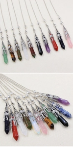 Detailed view of various hexagonal gemstone pendants with silver hollow filigree caps