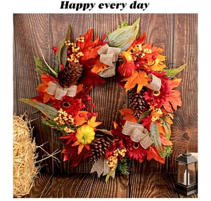 Detailed view of an autumn wreath with red flowers, pinecones, and pumpkins for home decor.