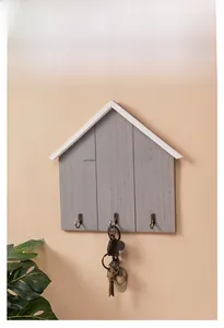 Close-up of wooden house-shaped key holder with HOME lettering and three metal hooks