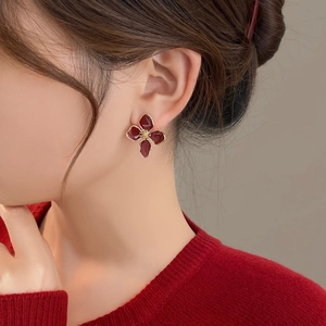 Elegant red four-petal flower earrings with gold edges on model for a vintage autumn look