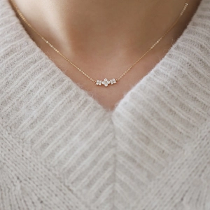 S925 sterling silver gold clover necklace with diamonds worn on a beige knit sweater