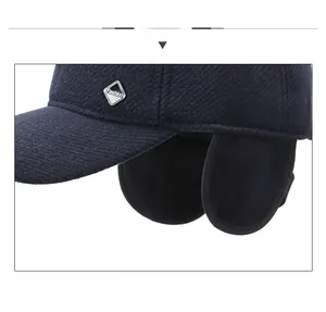 Detailansicht der Winter-Basecap mit Ohrenklappen und silbernem Fashion-Metalllogo
