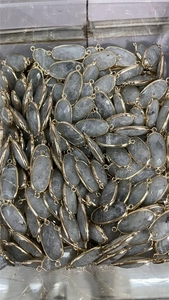 Detailed view of bulk gray faceted quartz connectors with gold-plated edges for DIY jewelry