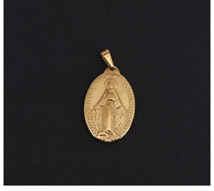 Macro shot of an oval 18K gold plated vintage religious medal pendant with relief