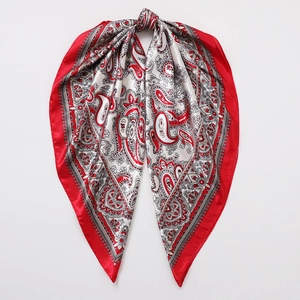 Detailed macro view of classic red paisley pattern on smooth satin finish silk scarf